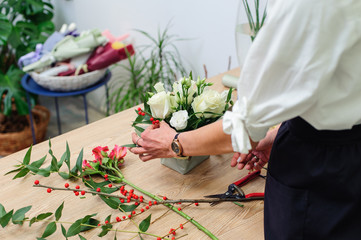 Gardener's in the flower shop make bouquet. Lifestyle flower shop. Beautiful flower composition. Detail.