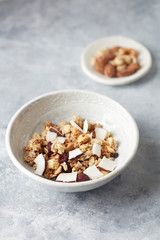 Bowl of granola with nuts, cranberry and cocoanut. Concept for a tasty and healthy meal. Stone background. Copy space. 