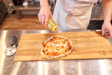 Pizza Margarita. Baked tasty margherita pizza in Traditional wood oven in Neapolitan restaurant, Italy.