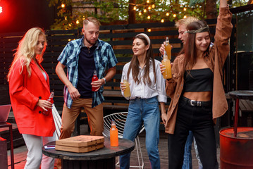 Group of friends are dancing at outdoors barbecue party in the house courtyard. - Powered by Adobe