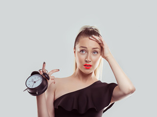 Oh, I forgot to change the time I got a date and it is already late. Young woman holding alarm...