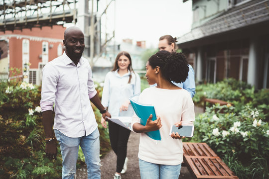 Modern students walking on terrace talking. - Powered by Adobe