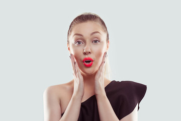 Surprised young woman with hands on cheeks over white light blue background