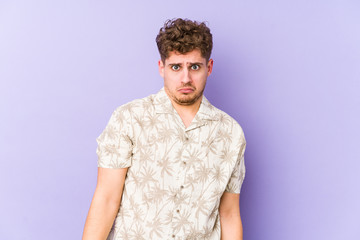 Young blond curly hair caucasian man isolated shrugs shoulders and open eyes confused.