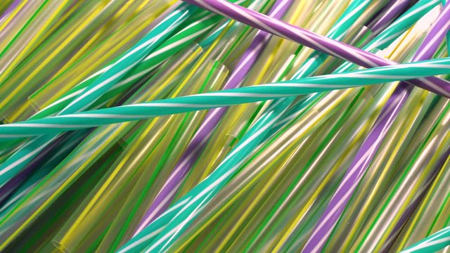 Plastic straws rotating. Straws are part of plastic pollution, damaing the environment because of its inability to decompose. Such trash is a hazard for the planet and needs to be recycled. Rotating 4