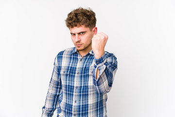 Young blond curly hair caucasian man isolated showing fist to camera, aggressive facial expression.