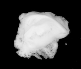 Foam bubble from soap or shampoo washing isolated on black background, top view. Foam background. White foam.