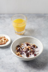 Bowl of granola with yogurt, nuts, cranberry and cocoanut. Concept for a tasty and healthy meal. Stone  background. 