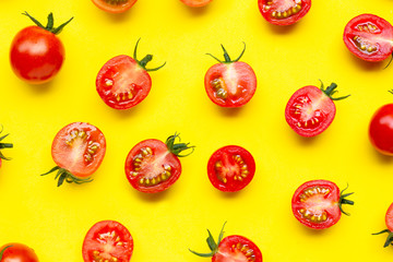 Fresh tomatoes, whole and half cut isolated on yellow background.