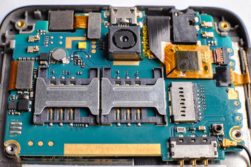 Blue green printed electronic circuit  board of a smartphone phone having small electronic...