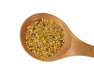 Pile of bee pollen in a wooden spoon isolated on white.