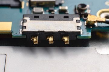 Fototapeta premium Contact group of the smartphone battery. Blue green printed electronic circuit board of a smartphone having small electronic components.