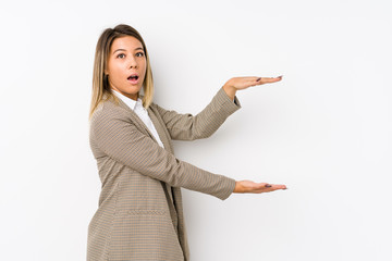 Young caucasian business woman isolated shocked and amazed holding a copy space between hands.