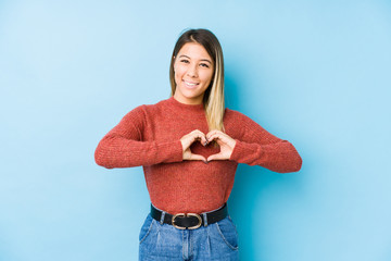 young caucasian woman posing isolated smiling and showing a heart shape with hands.