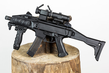 Czech submachine gun leaning on anvil with gray background.
