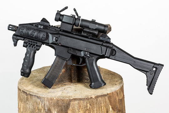 Czech submachine gun leaning on anvil with gray background.