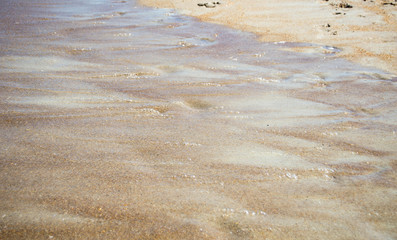 Fototapeta na wymiar Ocean water ripples over beach