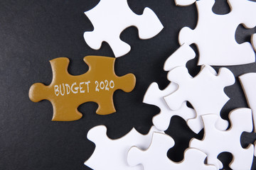 Fototapeta premium Budget 2020 printed on gold puzzle over white puzzle background