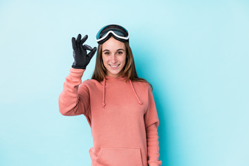 Young skier woman isolated cheerful and confident showing ok gesture.