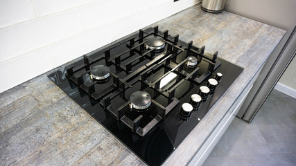 black glass hob built into a wooden worktop in the kitchen.