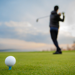 Batting golf balls on a grassy field at the tournament in the fall