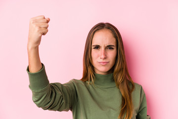 Young caucasian woman posing isolated  showing fist to camera, aggressive facial expression.
