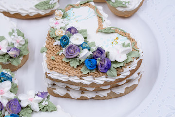 Obraz na płótnie Canvas Heart shaped cookies decorated with royal icing glaze and flowers