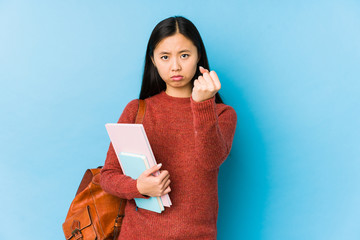 Obraz premium Young chinese student woman isolated showing fist to camera, aggressive facial expression.