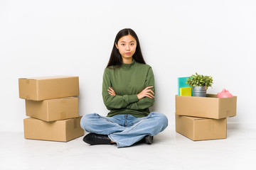 Young chinese woman moving to a new home unhappy looking in camera with sarcastic expression.