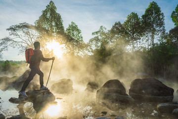 Traveler and Morning fog over hot spring at Chae Son National Park, Thailand