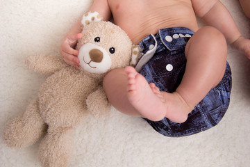 Little girl with teddy bear and cloth diaper