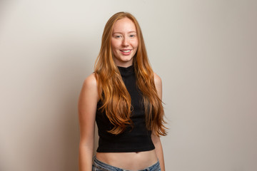 Fototapeta premium Portrait of beautiful cheerful redhead girl smiling laughing looking at camera over white background.