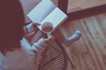 Happy woman drinking coffee and reading book at home in the morning,Relax time,Close up
