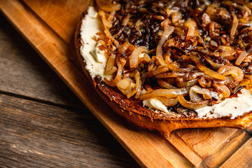 Homemade pizza with goat cheese, caramelized onion and balsamic vinegar. Selective focus. Shallow depth of field.