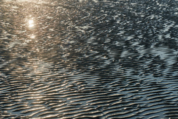 texture of wet sand on a beach during low tide.