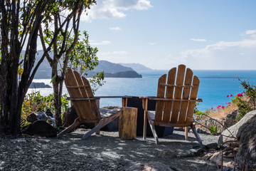 Pair of adirondack chairs looking onto Little Bay beach in Tortola BVI. Little gas fire pit to be fired up to enjoy the view.