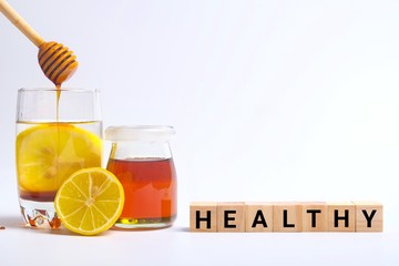 glass of water, honey and lemon isolated on white background 