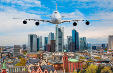 Airplane flying over business skyline of Frankfurt am Main, Germany - financial capital of the european union