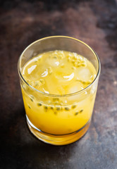 Old fahioned passion fruit cocktail on the rustic background. Selective focus. Shallow depth of field.