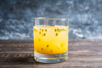 Old fahioned passion fruit cocktail on the rustic background. Selective focus. Shallow depth of...