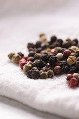 Pile of peppercorns on a white cloth napkin.