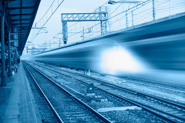 Fototapeta premium White high speed train runs on rail tracks . Train in motion