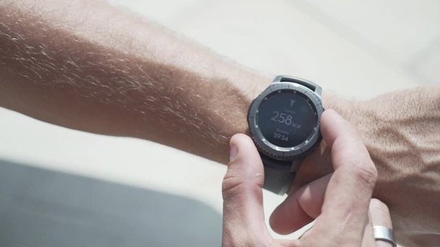Man is adjusting the time on his wristwatch