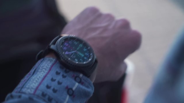 Man in a shirt is looking at his watch on his wrist. Watching the time.