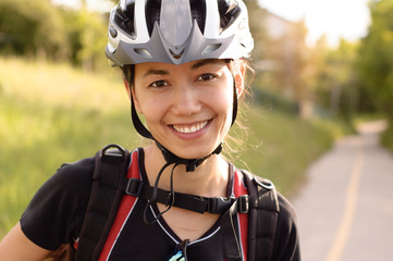 smiling beautiful young woman in a bike helmet commuting from work