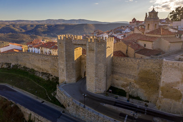 Sunset view of the Porta de Sant Miquel medieval gate protected by two octagonal towers with crenelation, murder hole, portcullis in Morella Castellon Spain 