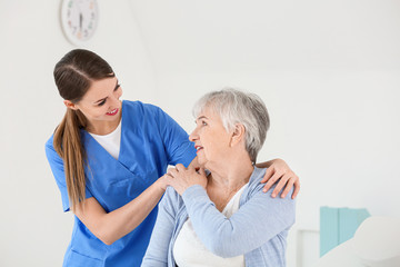 Obraz premium Female doctor with senior woman suffering from Parkinson syndrome in clinic