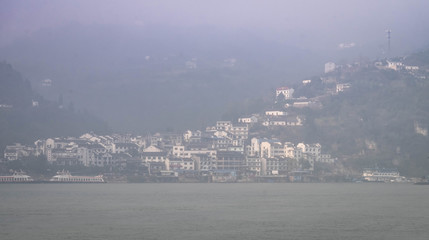 Fototapeta na wymiar The wooden village along with the hill beside the Yangtze river in the part of Three Gorges Dam.