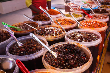 Wide Variety Of Quality Hot Sour Spicy Tangy Pickles Indian Masala Aachar Or Achar Placed In Big Containers With Spoon