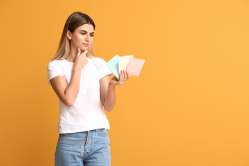 Young woman with menstrual pads on color background